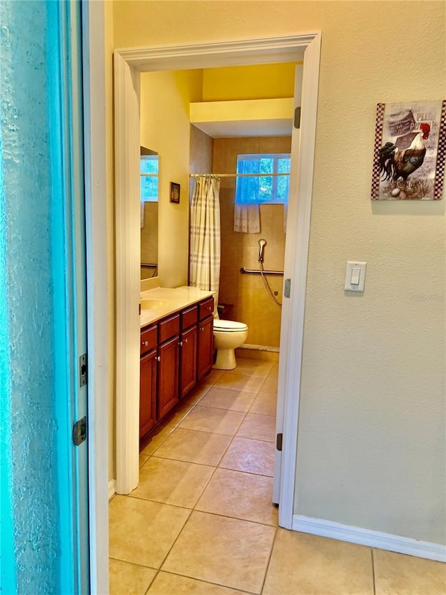 bathroom featuring curtained shower, tile patterned floors, vanity, and toilet