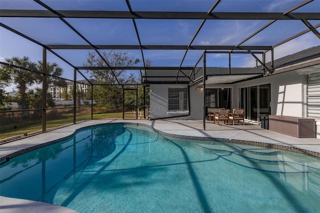 view of swimming pool featuring glass enclosure and a patio