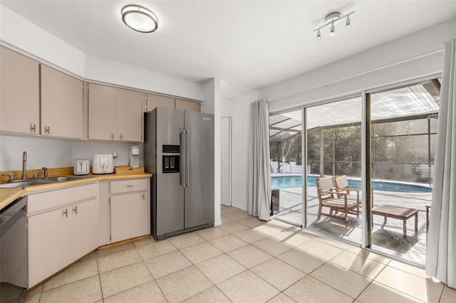 kitchen with appliances with stainless steel finishes, light tile patterned floors, and sink