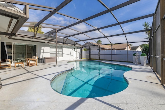 view of pool featuring glass enclosure and a patio area