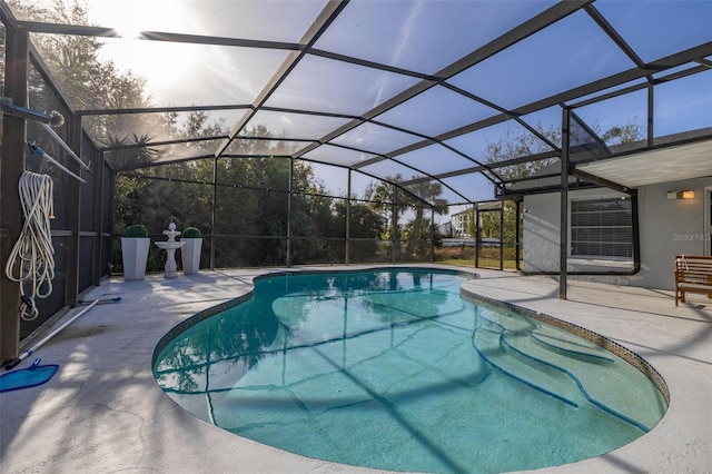 view of pool featuring glass enclosure and a patio area