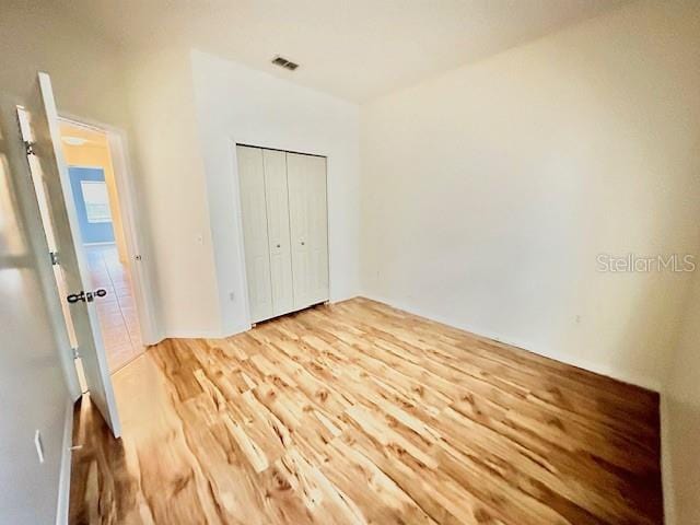 unfurnished bedroom featuring hardwood / wood-style flooring and a closet