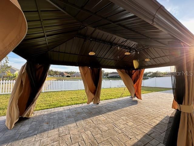 view of property's community featuring a gazebo, a water view, a yard, and a patio