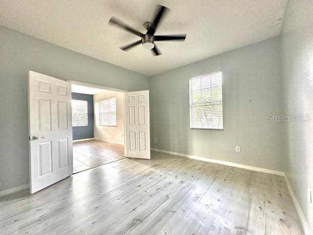 unfurnished bedroom with ceiling fan and light hardwood / wood-style floors