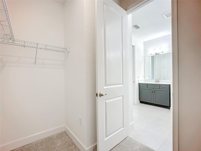 walk in closet with sink and light tile patterned floors