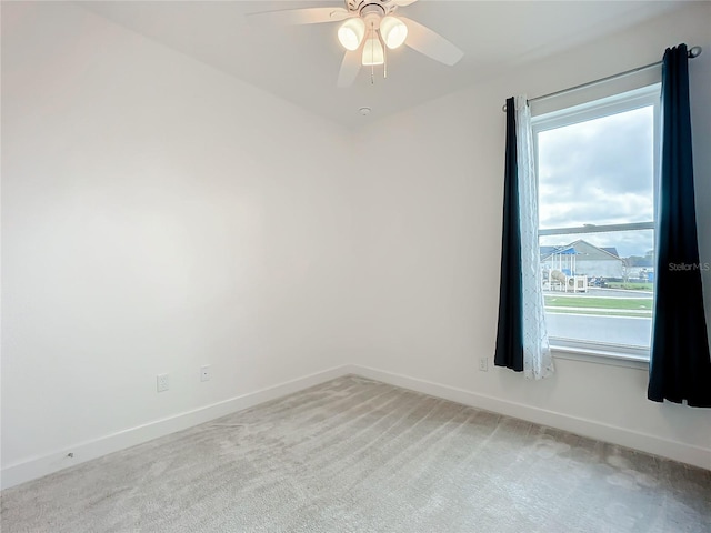 carpeted spare room with ceiling fan