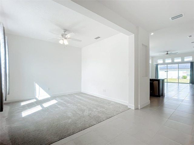 spare room featuring light carpet and ceiling fan