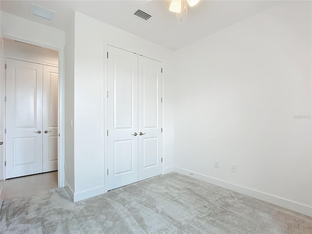 unfurnished bedroom with ceiling fan, a closet, and light colored carpet