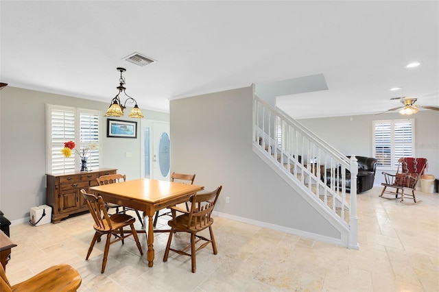 dining room featuring ceiling fan with notable chandelier