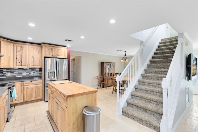 kitchen with a center island, light brown cabinets, wood counters, a chandelier, and appliances with stainless steel finishes