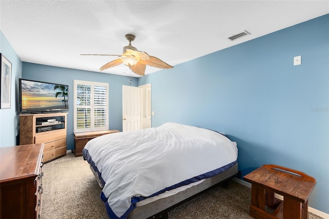 bedroom with ceiling fan, carpet, and a textured ceiling