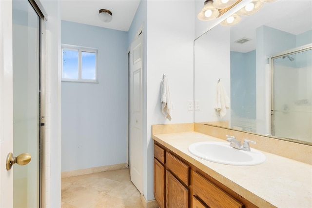 bathroom featuring vanity, tile patterned floors, and a shower with door