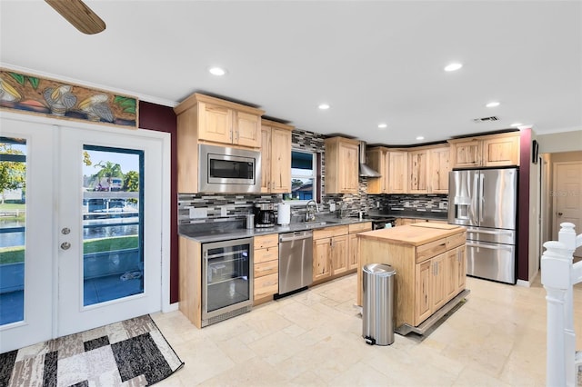 kitchen with sink, beverage cooler, stainless steel appliances, tasteful backsplash, and light brown cabinetry