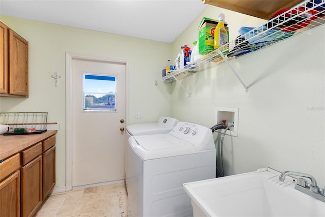 laundry area with cabinets, separate washer and dryer, and sink