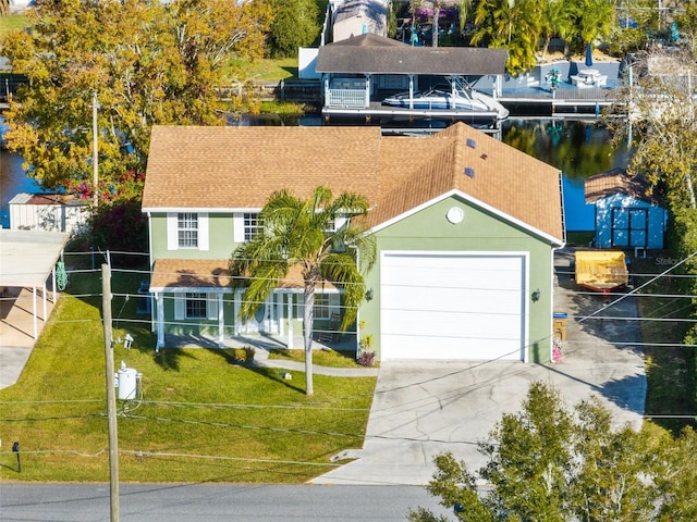 view of front of house with a water view, a front yard, and a garage