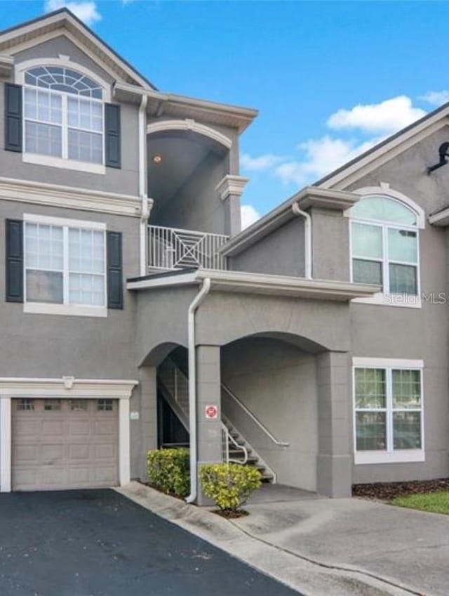 view of property with a balcony and a garage