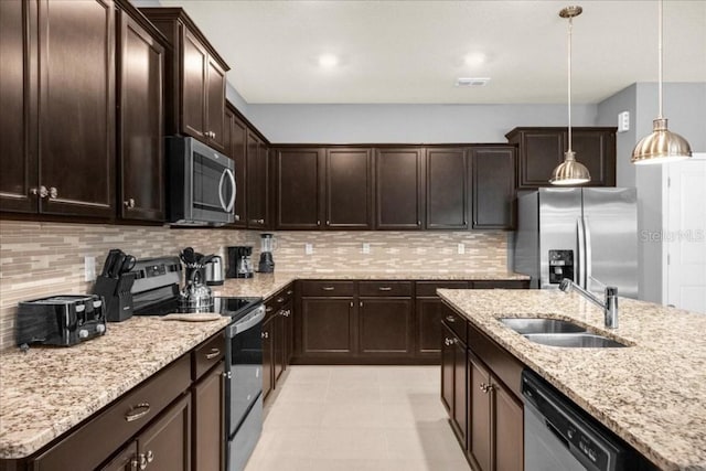 kitchen featuring dark brown cabinetry, sink, decorative light fixtures, decorative backsplash, and appliances with stainless steel finishes