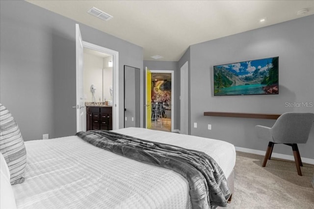 bedroom featuring connected bathroom and carpet floors