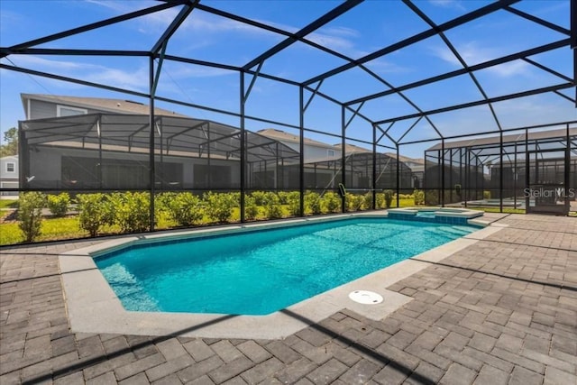 view of pool featuring glass enclosure, a patio area, and an in ground hot tub