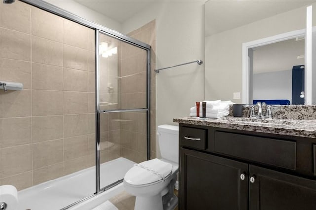 bathroom featuring vanity, an enclosed shower, and toilet