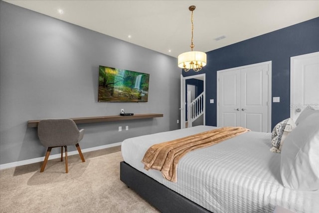 bedroom featuring light colored carpet and an inviting chandelier