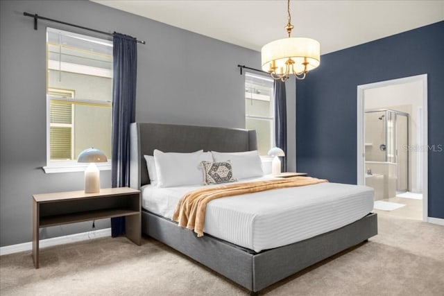 carpeted bedroom with connected bathroom and an inviting chandelier