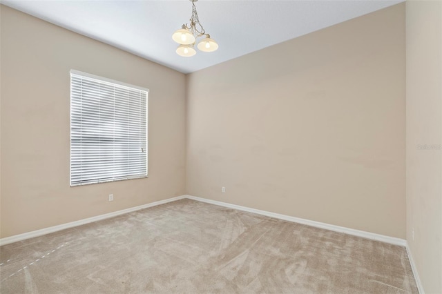 carpeted empty room with a chandelier