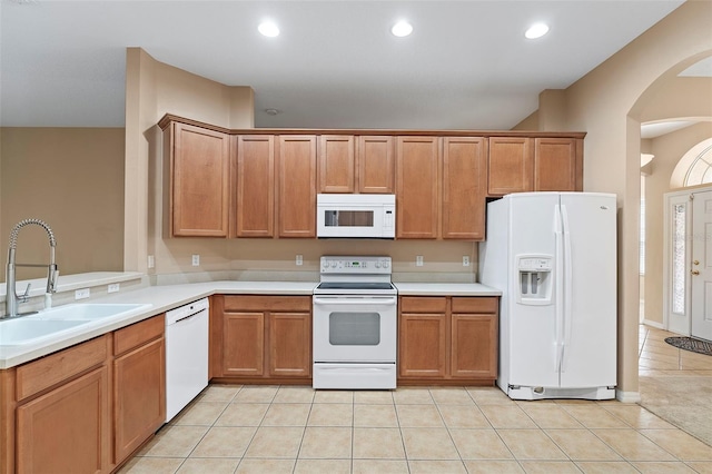 kitchen featuring light tile patterned flooring, sink, and white appliances