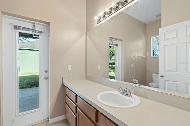 bathroom featuring vanity, toilet, and a healthy amount of sunlight