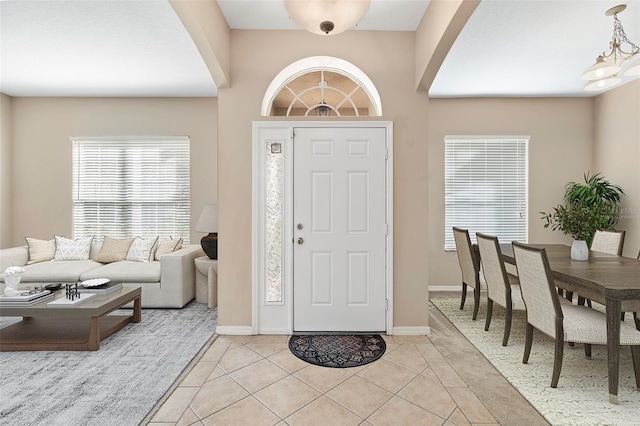 tiled entrance foyer with an inviting chandelier