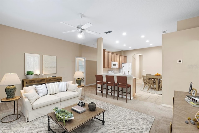 carpeted living room with ceiling fan