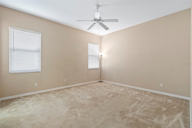 carpeted spare room with ceiling fan