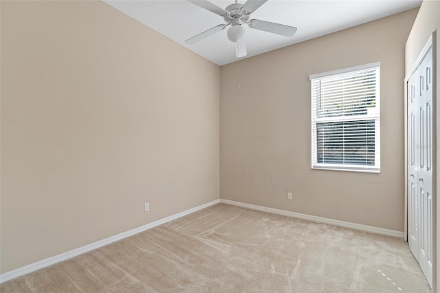 unfurnished bedroom with ceiling fan, light colored carpet, and a closet