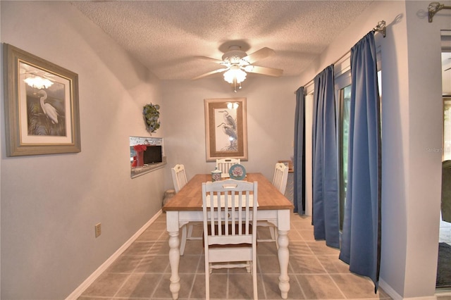 tiled dining room featuring a textured ceiling and ceiling fan