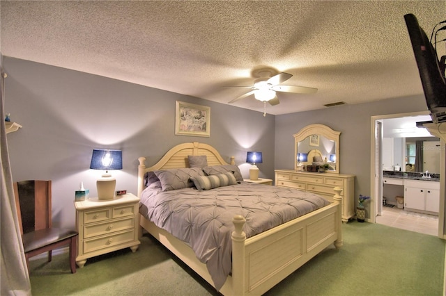 carpeted bedroom featuring a textured ceiling, ceiling fan, connected bathroom, and sink