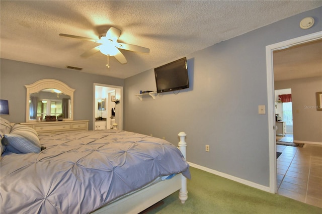 bedroom with a textured ceiling, ceiling fan, and dark carpet