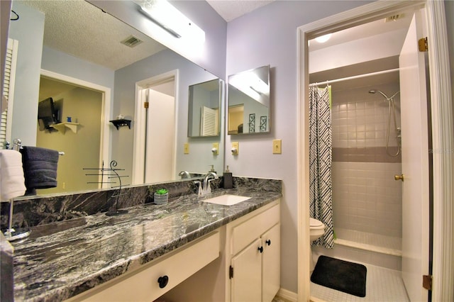 bathroom featuring toilet, walk in shower, and vanity