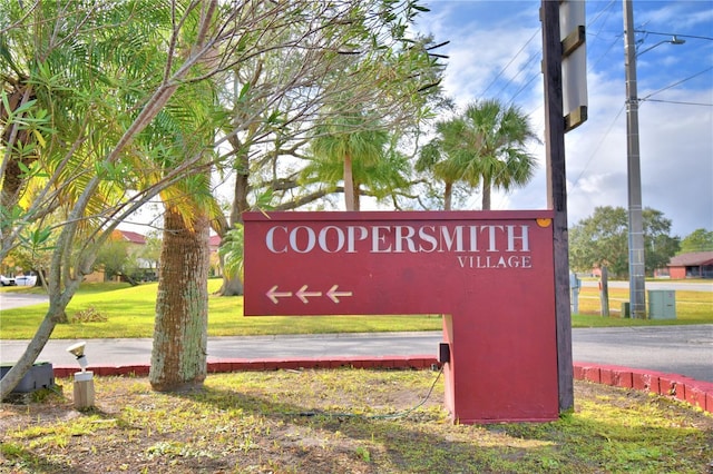 community / neighborhood sign featuring a yard