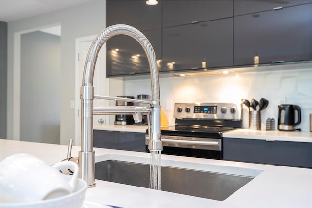 kitchen with backsplash, sink, and stainless steel range with electric cooktop