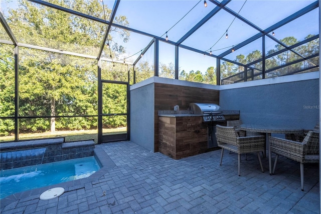 view of patio / terrace featuring a lanai, area for grilling, and exterior kitchen