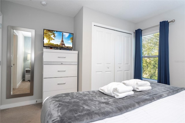 bedroom with a closet, carpet floors, and a textured ceiling