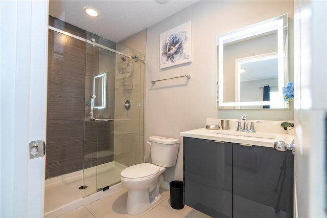 bathroom featuring tile patterned floors, vanity, toilet, and walk in shower