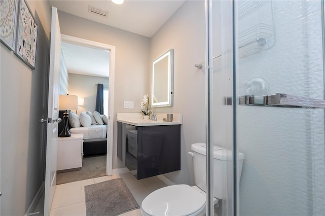 bathroom featuring tile patterned flooring, vanity, toilet, and a shower with shower door