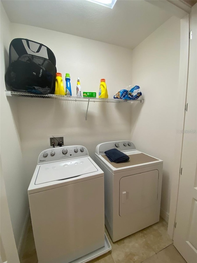 laundry room with independent washer and dryer and light tile patterned floors