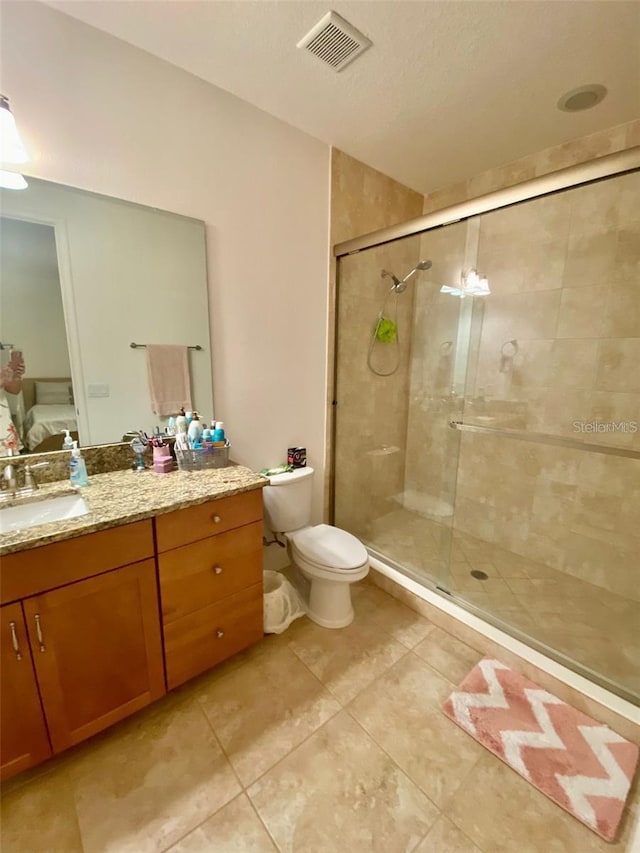 bathroom with tile patterned floors, vanity, toilet, and an enclosed shower