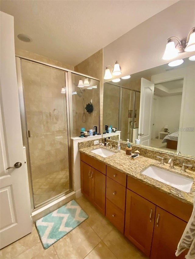 bathroom with tile patterned flooring, vanity, and a shower with door