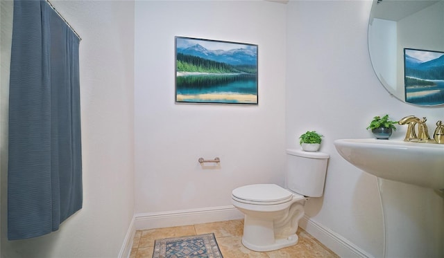 bathroom featuring tile patterned flooring, baseboards, and toilet