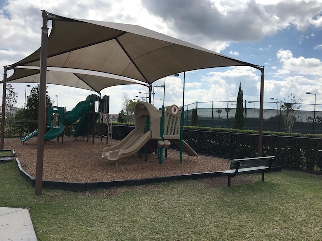 community playground with fence and a lawn