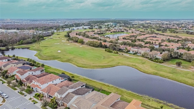 drone / aerial view with view of golf course, a water view, and a residential view