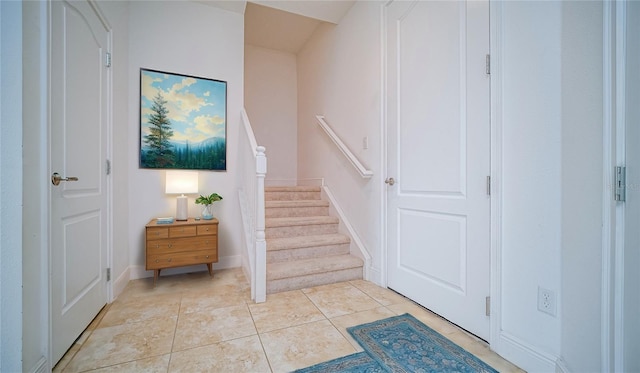 stairs with baseboards and tile patterned floors